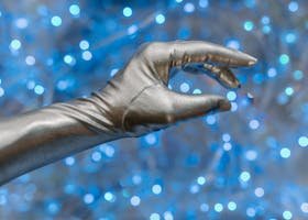 Close-up of a metallic glove against a vibrant blue bokeh background, evoking a futuristic theme.